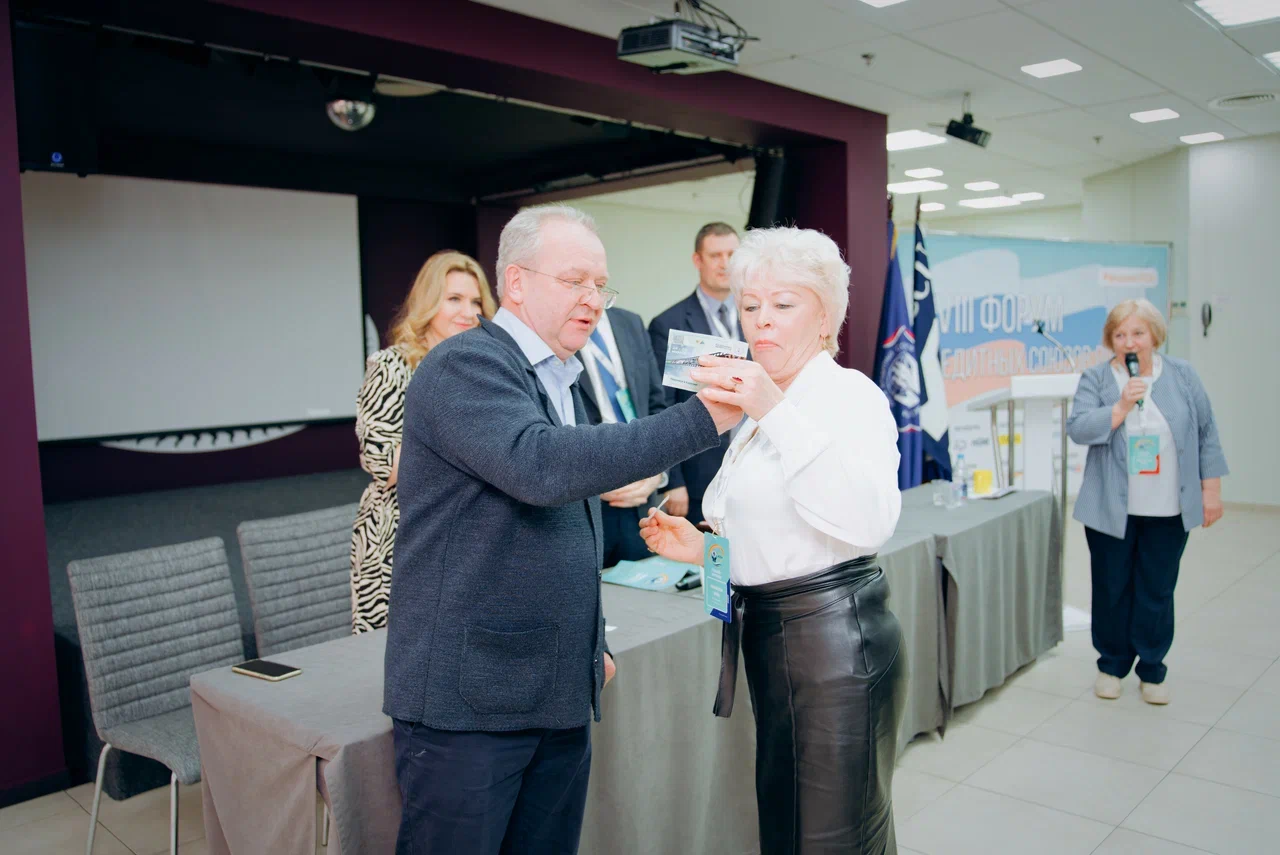 Илья Горохов вручает сертификат победителю розыгрыша на бесплатное проживание на Слёте "Карельский Берег - 2024"